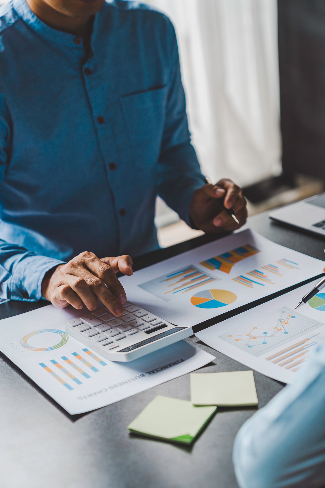 Paperwork and hands on a board room table at a business presentation or seminar. analysis report Che